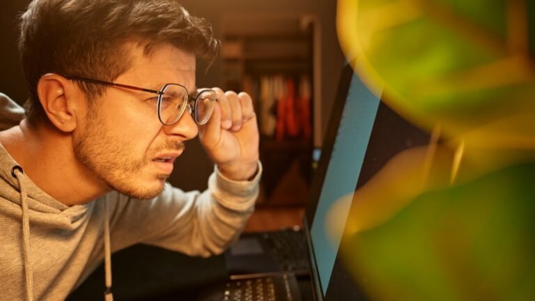 Man squinting at computer screen illustrating having too many browser tabs open