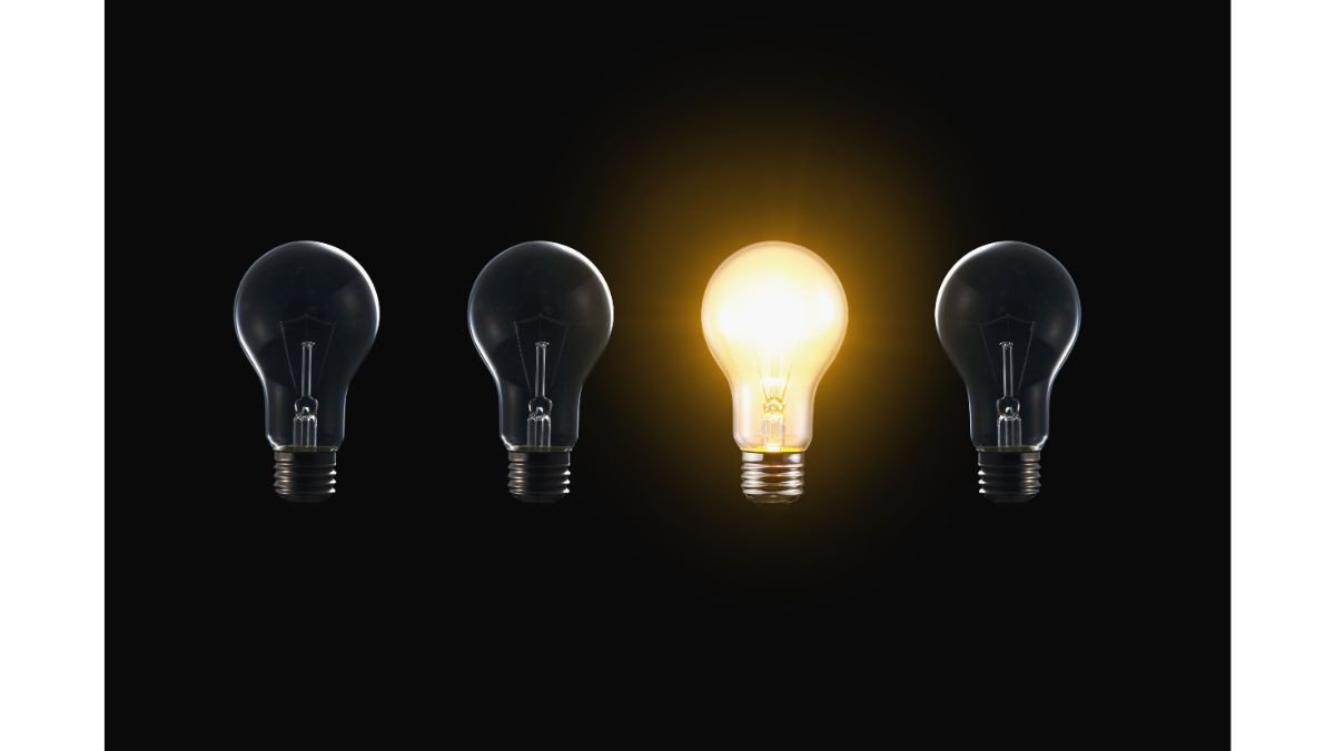One illuminated lightbulb among dark bulbs representing mental clarity and focus emerging from mental clutter