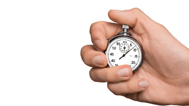Hand holding stopwatch representing the two-minute rule for building habits effectively