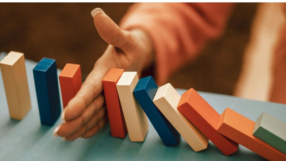 Hand blocking falling dominoes showing how to avoid common habit mistakes