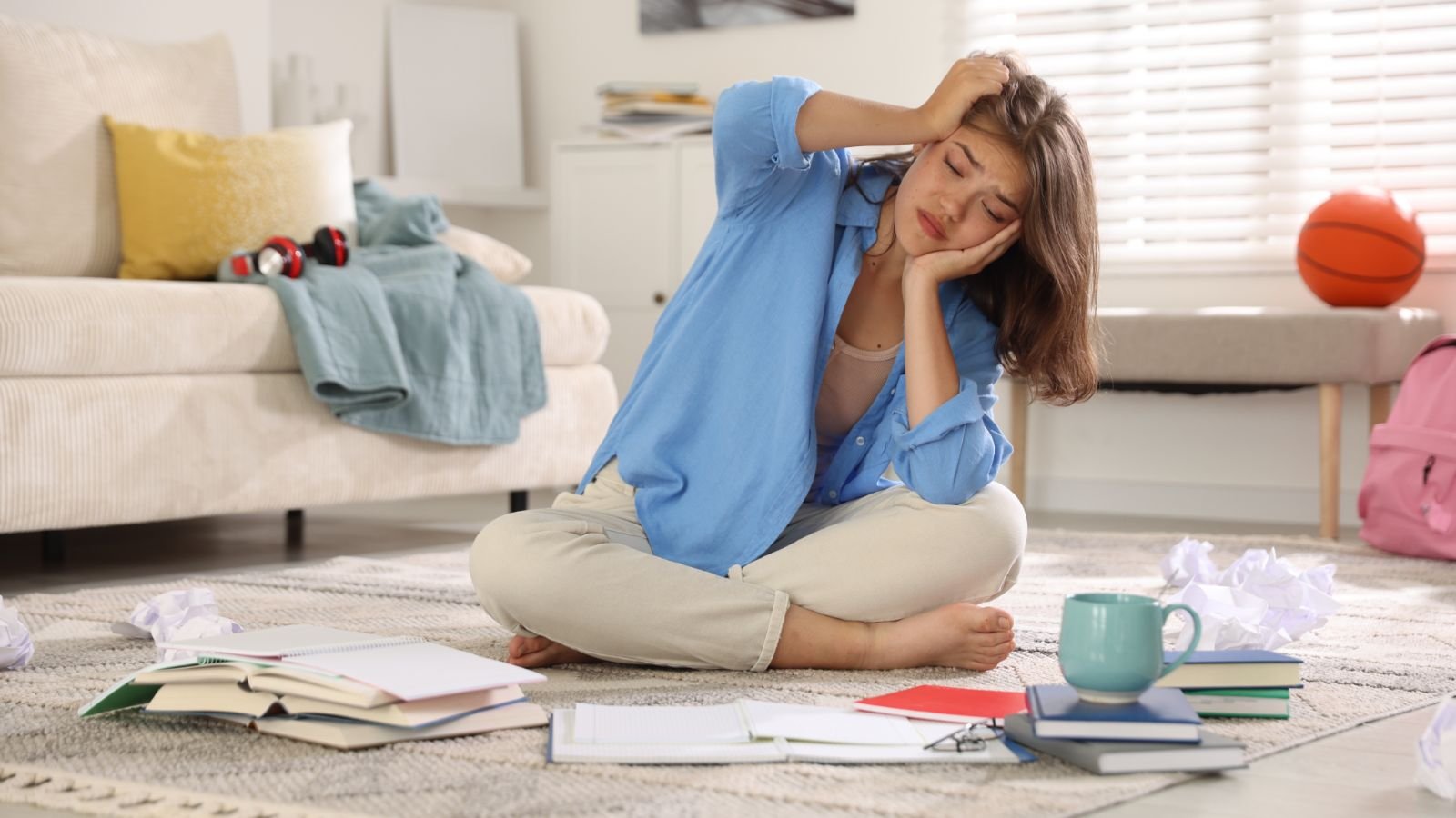 Student looking overwhelmed with too many books and notes