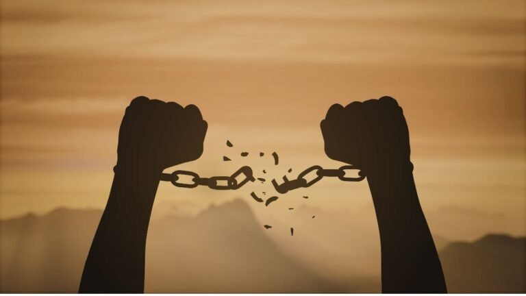 Hands breaking chains at sunrise symbolising freedom from bad habits