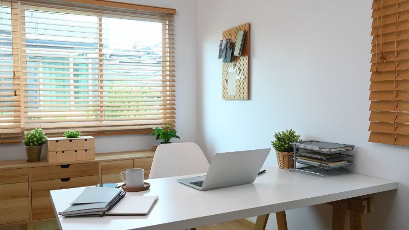 Home office desk positioned near large window with natural daylight