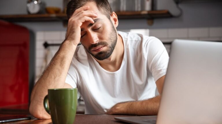 Man looking tired at desk, showing afternoon mental fatigue and energy depletion