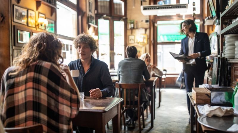 People sitting in a coffee shop, representing a low-pressure practice environment for remembering names and faces