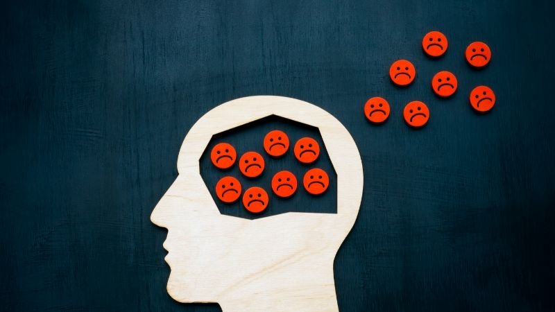 Graphic of a human head with negative thoughts inside and outside, illustrating overthinking